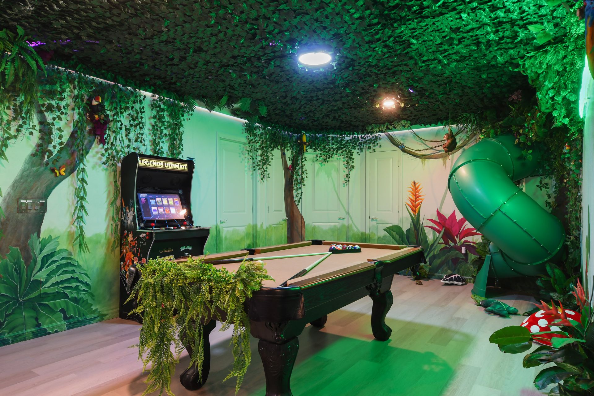 Adventure-themed game room with jungle decor, arcade games, pool table, and a slide!