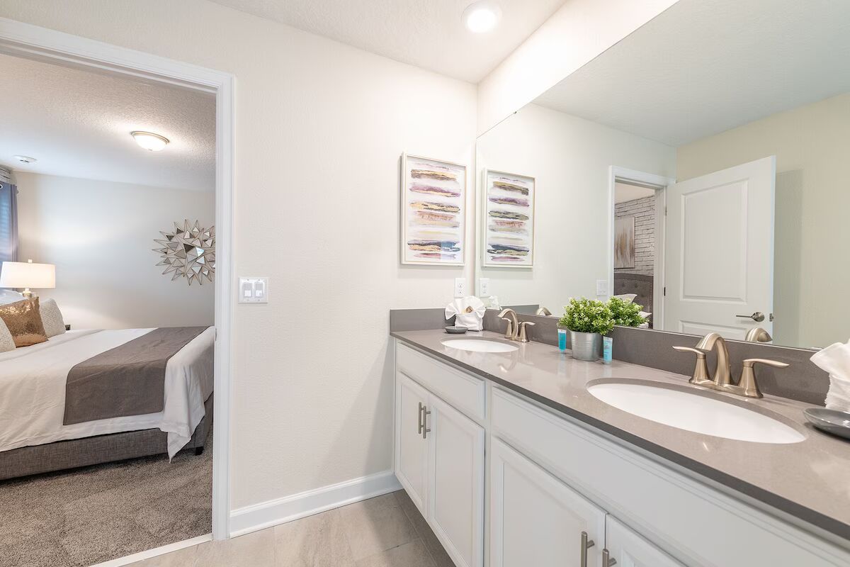 Stylish ensuite with dual sinks, modern fixtures, and direct bedroom access.