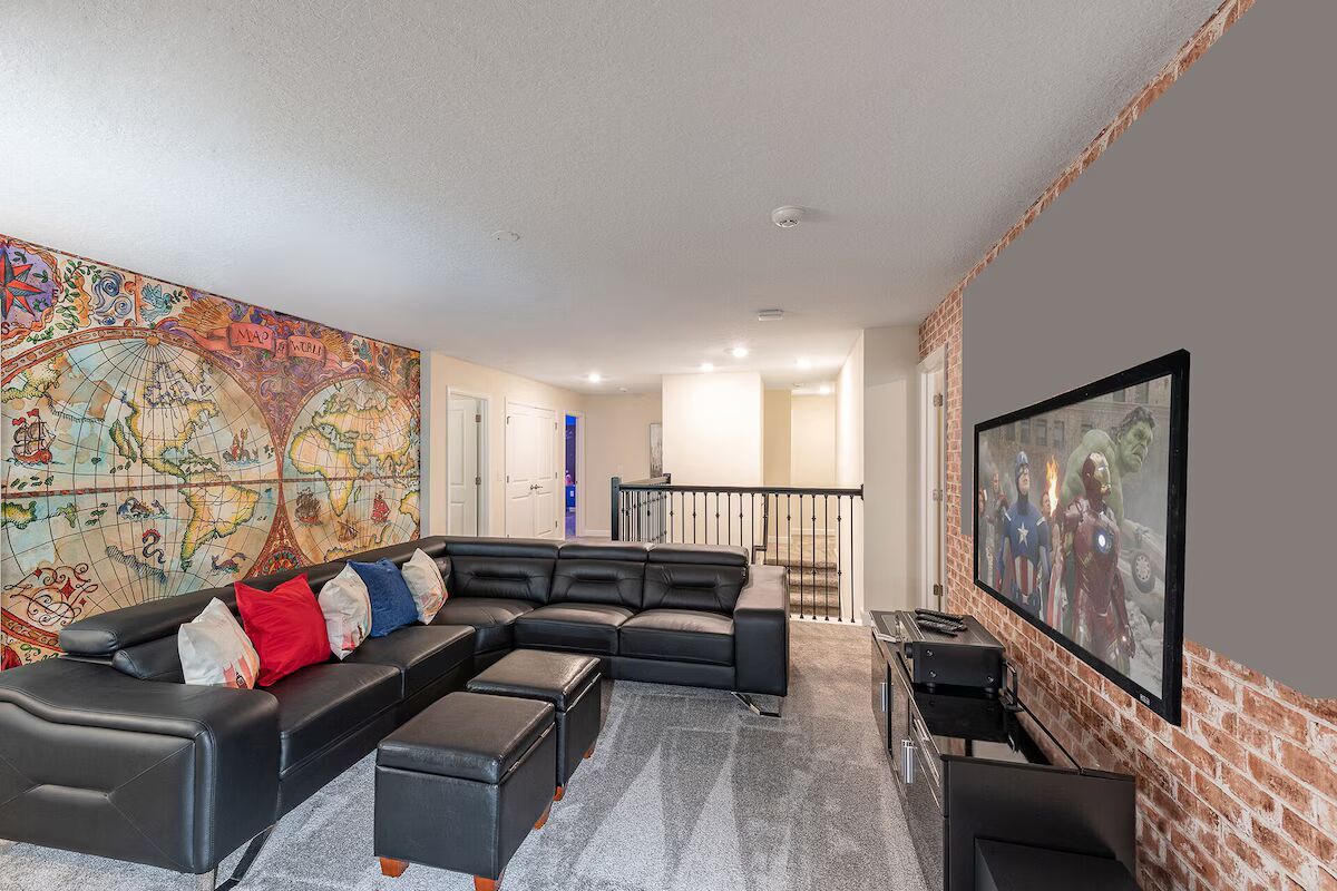 Cozy upstairs loft with leather sectional, big screen TV, and world map mural!