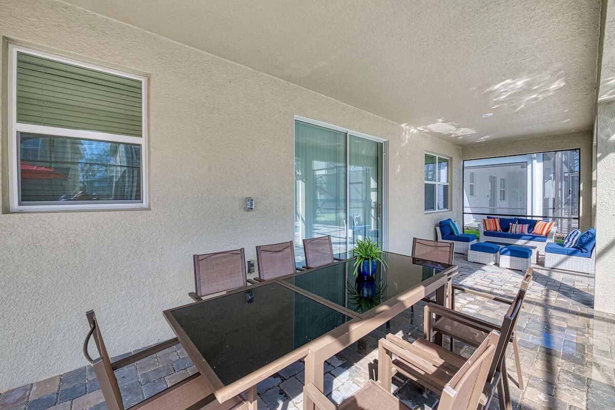 Covered patio with dining for eight and cozy lounge seating for ultimate comfort.