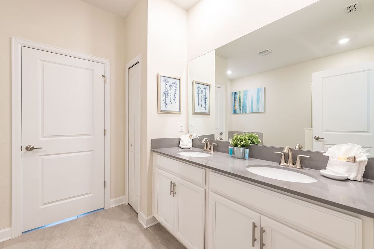 Bright, modern bathroom with double sinks, sleek counters, and elegant finishes.