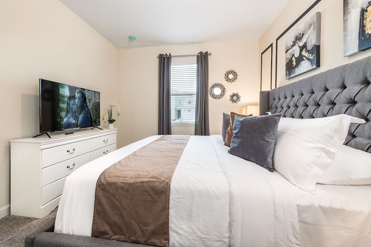 Modern king bedroom with plush bedding, stylish decor, and a smart TV setup!