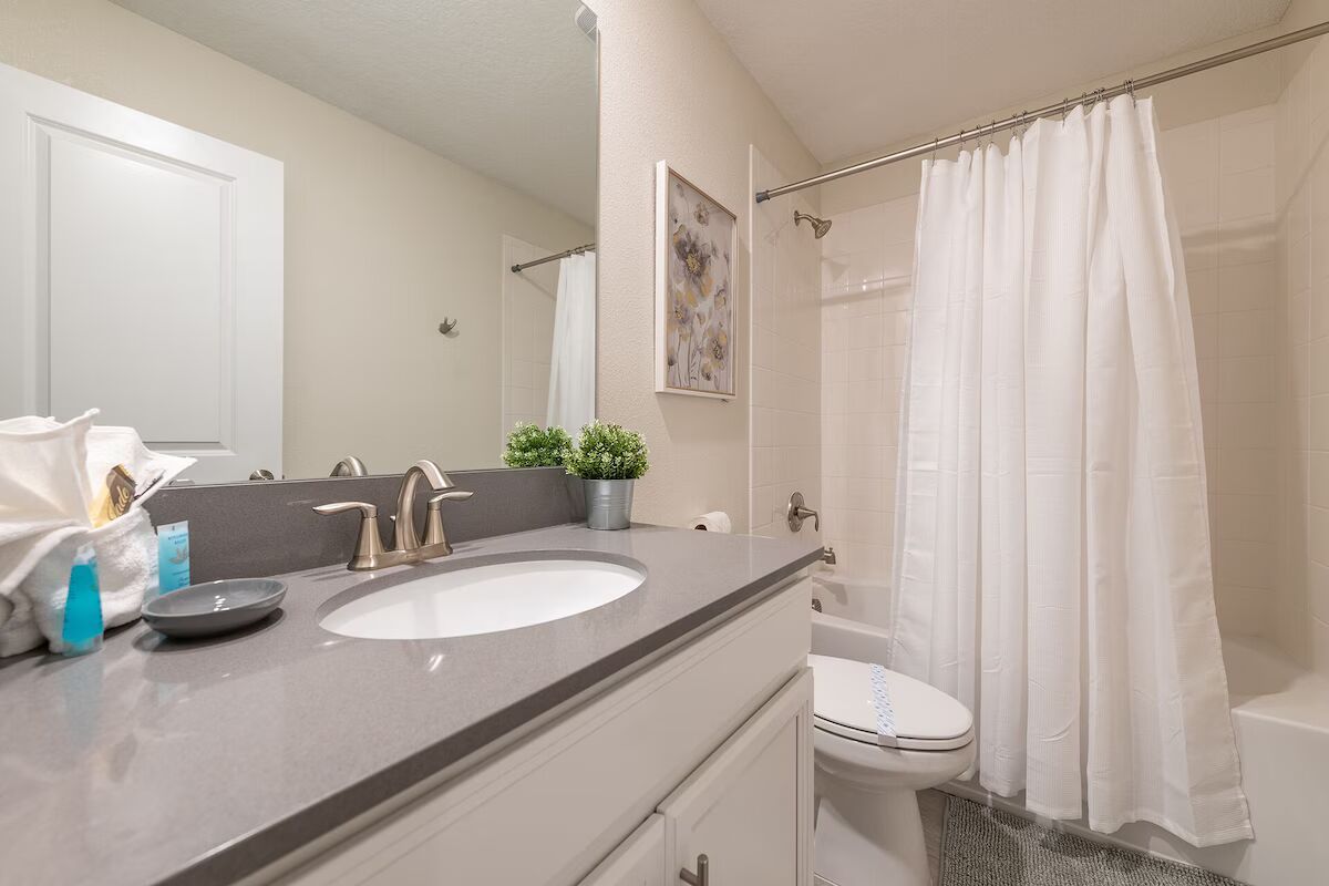 Clean and modern full bathroom with sleek vanity and a shower-tub combo.