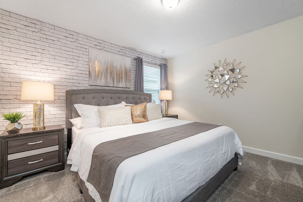 Chic king bedroom with modern décor, brick accent wall, and cozy elegance!