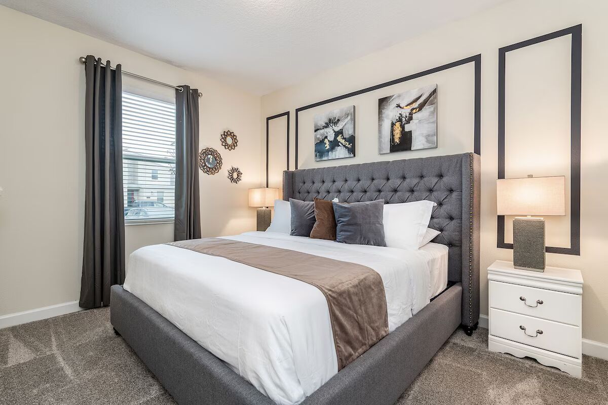 Sophisticated king bedroom with tufted headboard, warm tones, and chic decor!