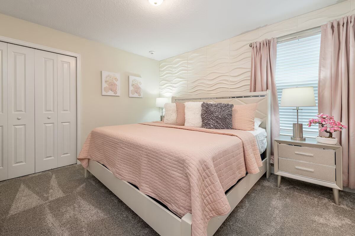 Elegant blush-toned bedroom with king bed, textured wall, and soft modern style!